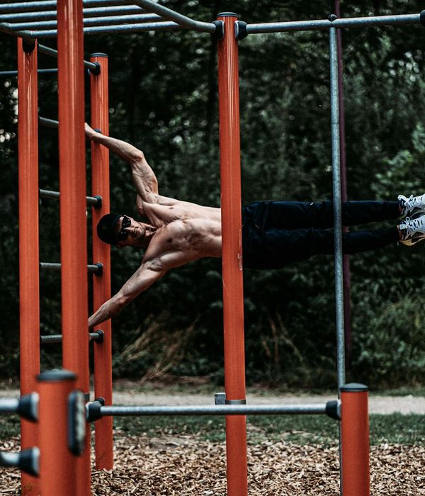 Man performing a controlled strength exercise in a modern gym.